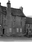 Old photograph with thatched roof and front chimney.